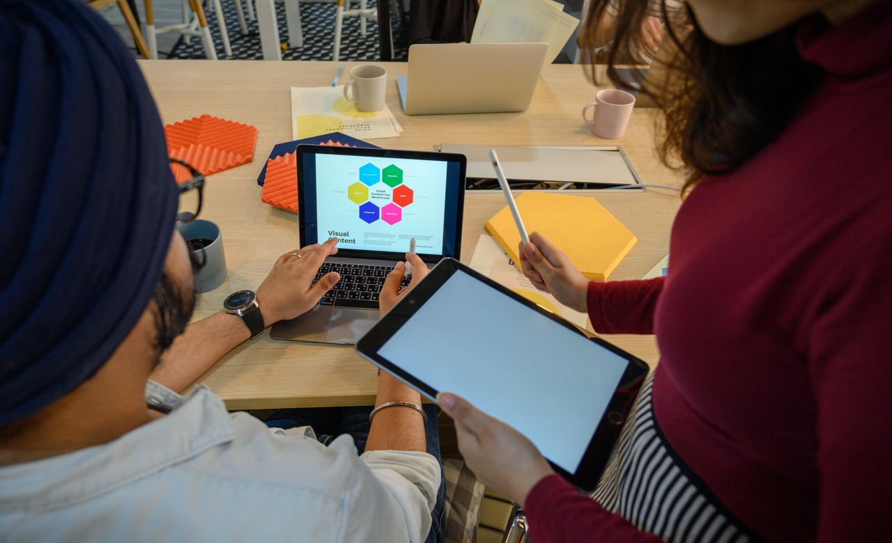 Creative meeting with digital devices in a modern office, showcasing teamwork and collaboration.